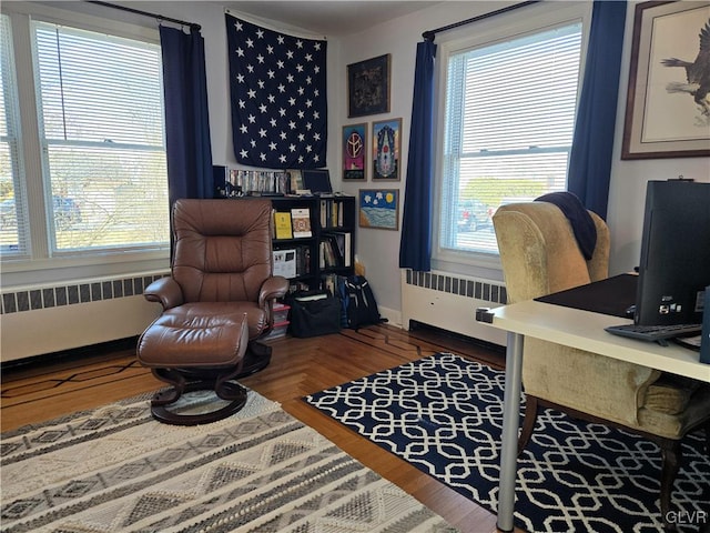 office space featuring radiator heating unit and a healthy amount of sunlight