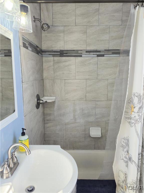 bathroom with a shower with shower curtain and sink