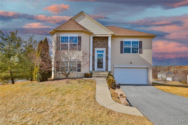 split foyer home featuring a yard and a garage