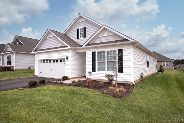 view of front of house featuring an attached garage, aphalt driveway, and a front yard