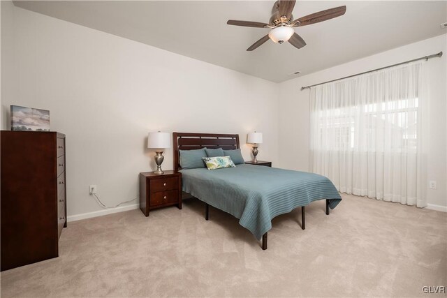 bedroom with light carpet, ceiling fan, and baseboards