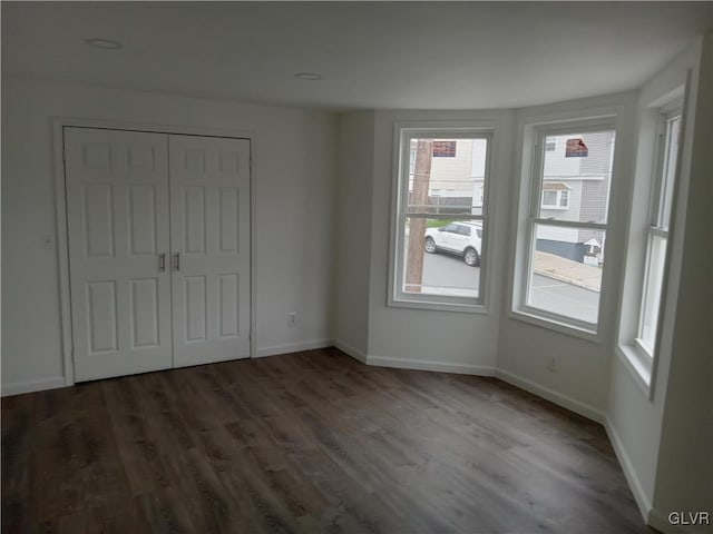 unfurnished bedroom featuring a closet and dark hardwood / wood-style flooring