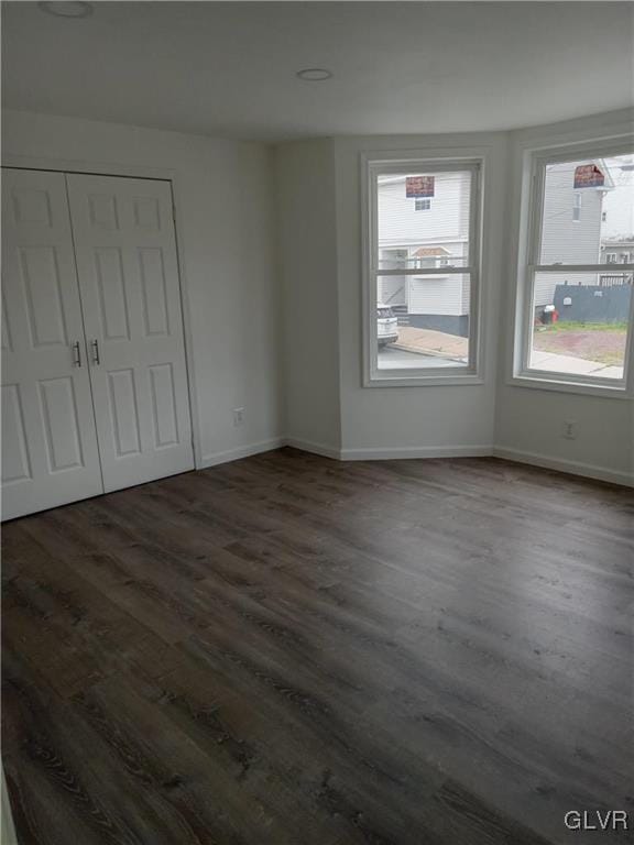 unfurnished bedroom featuring dark wood-type flooring and a closet