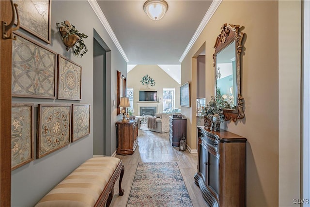 corridor with vaulted ceiling, crown molding, and light hardwood / wood-style flooring