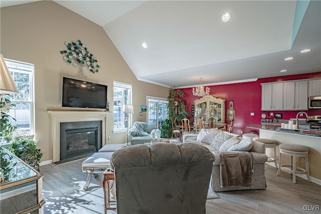 living room featuring light hardwood / wood-style floors, vaulted ceiling, and a chandelier