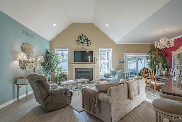 living room with high vaulted ceiling, an inviting chandelier, and wood-type flooring