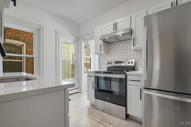 kitchen with stainless steel appliances, light countertops, white cabinets, and under cabinet range hood