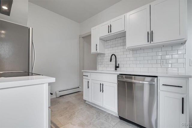 kitchen with a baseboard radiator, light countertops, backsplash, appliances with stainless steel finishes, and white cabinets