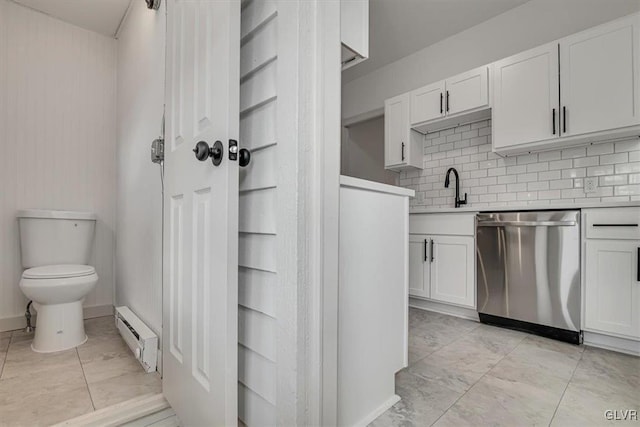 kitchen with light countertops, stainless steel dishwasher, and white cabinetry