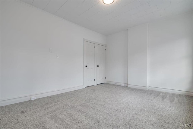 carpeted spare room featuring baseboards