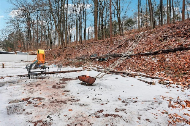 yard covered in snow featuring a playground