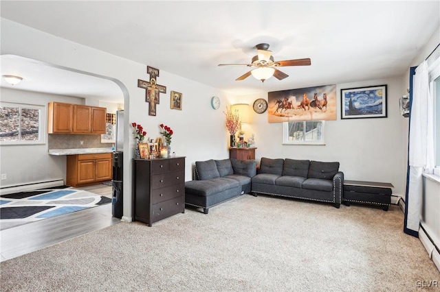 living room featuring a baseboard radiator, light colored carpet, and ceiling fan