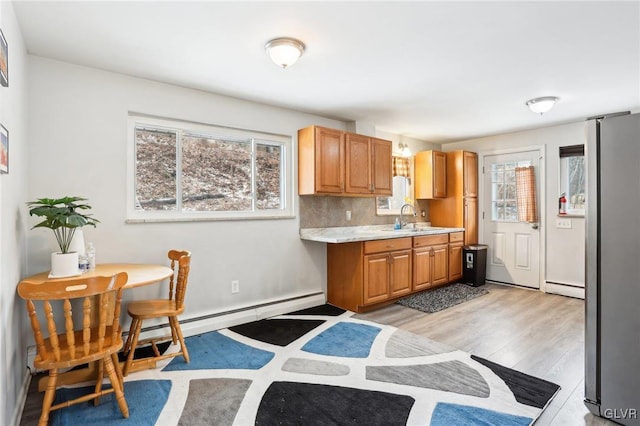 kitchen with plenty of natural light, sink, stainless steel fridge, and light hardwood / wood-style floors