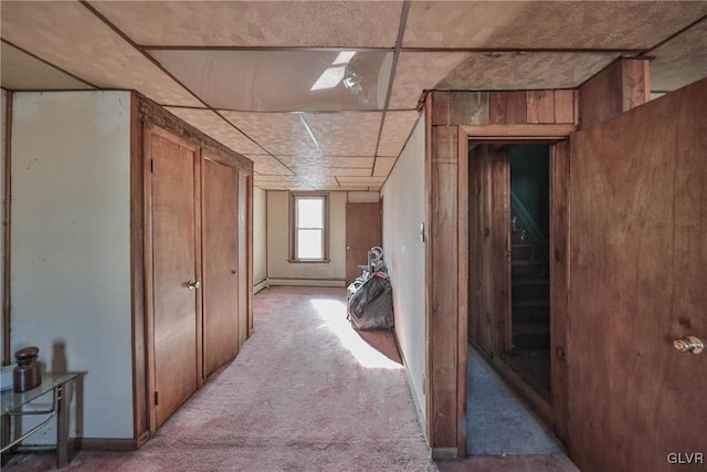 corridor featuring a baseboard radiator and light colored carpet