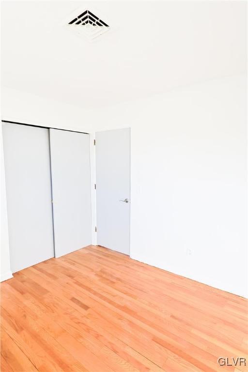 unfurnished bedroom featuring a closet and wood-type flooring