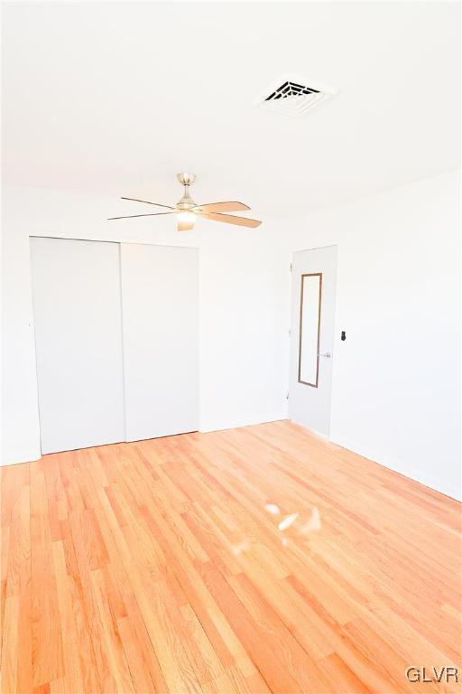 empty room with light wood-type flooring and ceiling fan