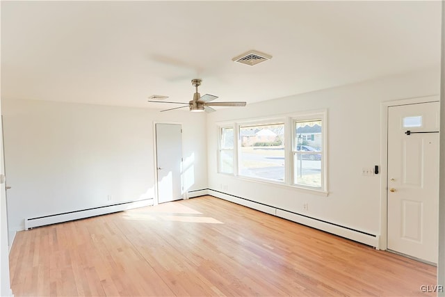 spare room with ceiling fan, light wood-type flooring, and a baseboard radiator