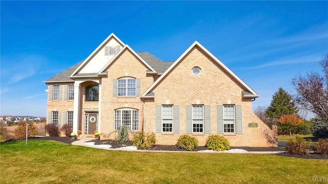 view of front of home featuring a front yard and brick siding