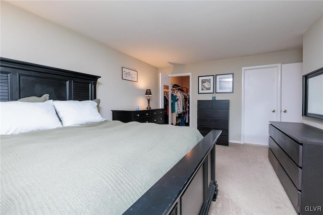 carpeted bedroom with a spacious closet and a closet