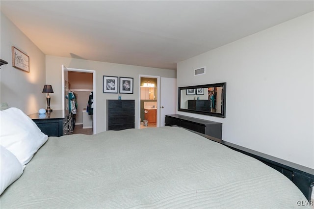 bedroom featuring a closet, connected bathroom, and a spacious closet