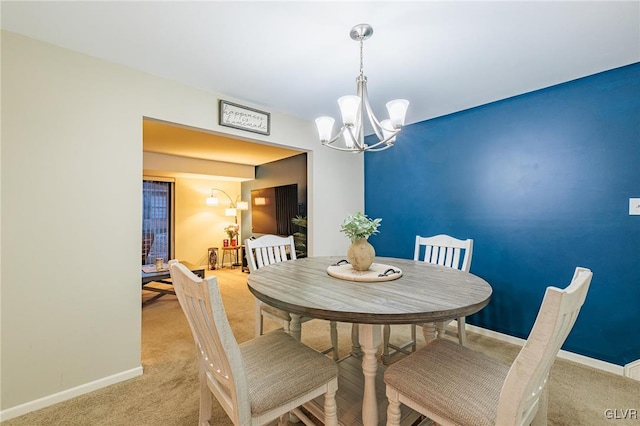 carpeted dining space featuring an inviting chandelier