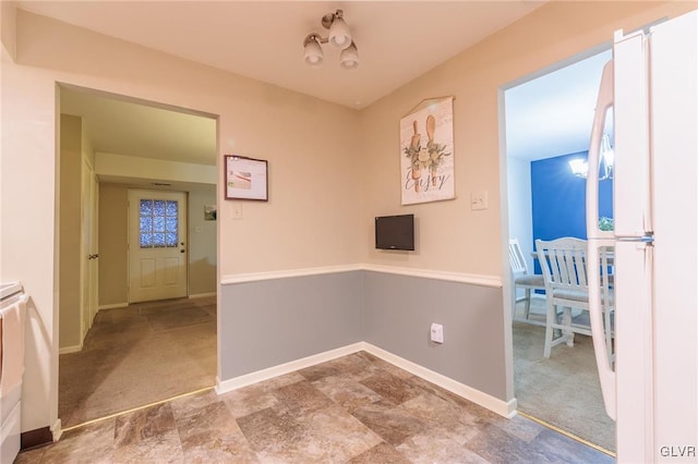 corridor featuring a chandelier and light colored carpet