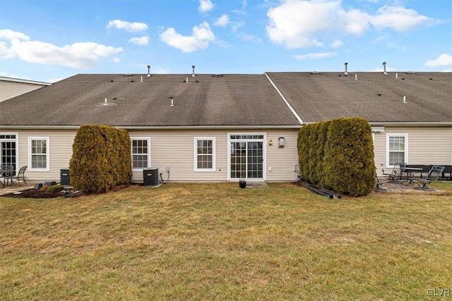 back of house with a yard, central AC unit, a patio, and a shingled roof