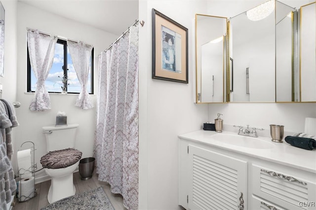 full bathroom featuring vanity, toilet, and wood finished floors