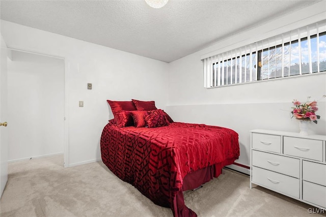 bedroom featuring multiple windows, baseboards, a textured ceiling, and light colored carpet