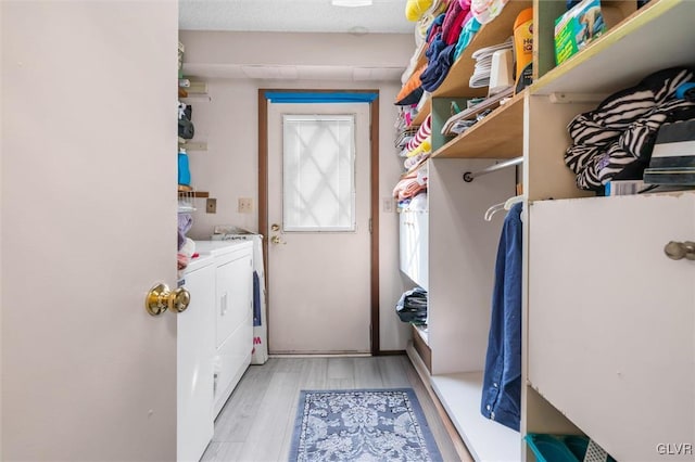 laundry room with laundry area, light wood finished floors, and separate washer and dryer