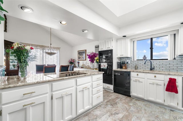 kitchen with white cabinets, vaulted ceiling, black appliances, pendant lighting, and a sink