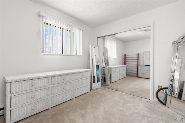 bedroom featuring a closet, a textured ceiling, and light colored carpet