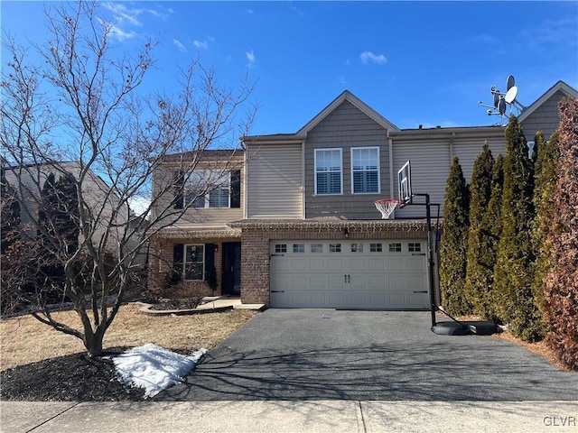 view of front of home featuring brick siding, aphalt driveway, and an attached garage