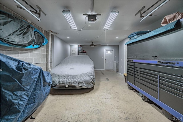 garage featuring concrete block wall and a garage door opener