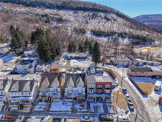 snowy aerial view with a residential view and a mountain view