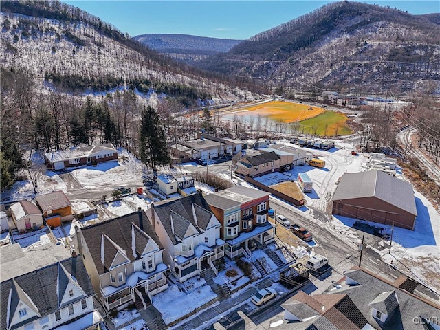 snowy aerial view featuring a residential view and a mountain view