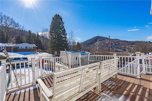 snow covered deck with a mountain view