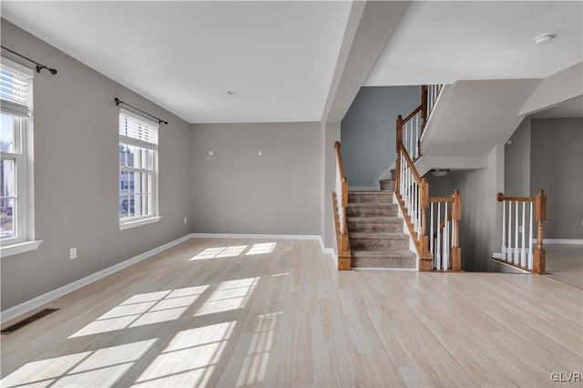 interior space featuring a wealth of natural light, light wood-type flooring, and visible vents