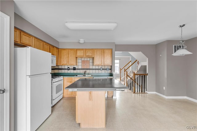 kitchen with white appliances, a center island, a kitchen bar, pendant lighting, and a sink