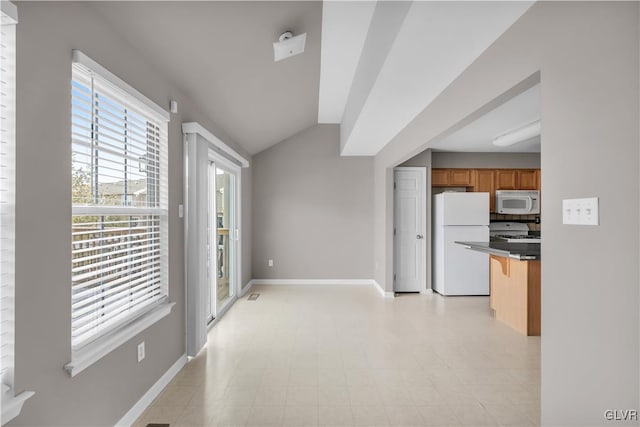 kitchen featuring white appliances, baseboards, a breakfast bar, brown cabinets, and vaulted ceiling