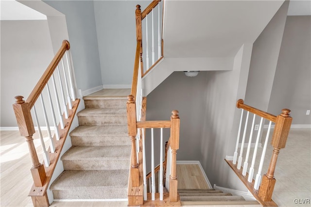 stairway featuring wood finished floors and baseboards