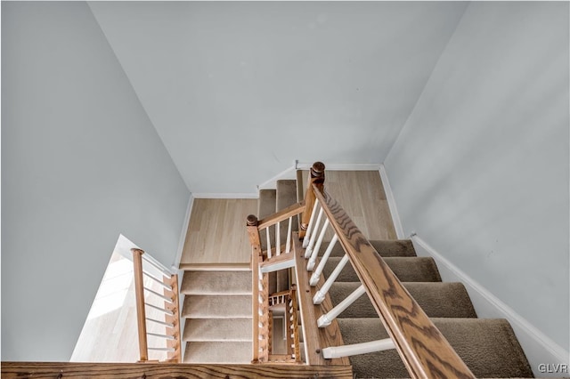 staircase featuring baseboards and wood finished floors