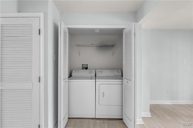 laundry area featuring light wood-type flooring, laundry area, baseboards, and washing machine and clothes dryer