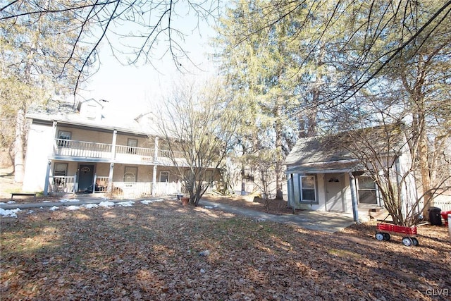 rear view of house with a balcony and stucco siding