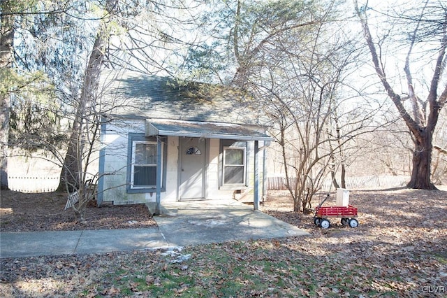 view of front of home featuring a shingled roof and fence