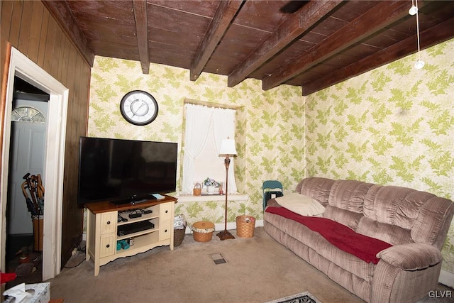 living area featuring wallpapered walls, beam ceiling, and carpet flooring