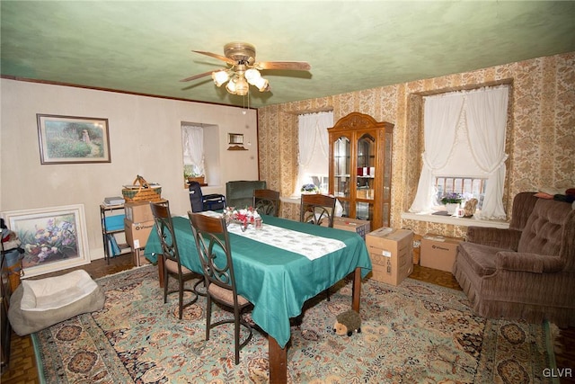 dining area featuring ceiling fan and wallpapered walls