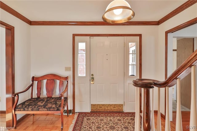 foyer entrance featuring ornamental molding, baseboards, and stairs