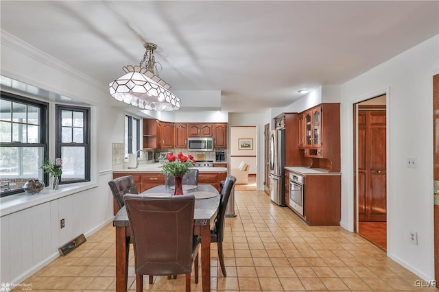 dining area featuring ornamental molding, baseboards, and light tile patterned floors