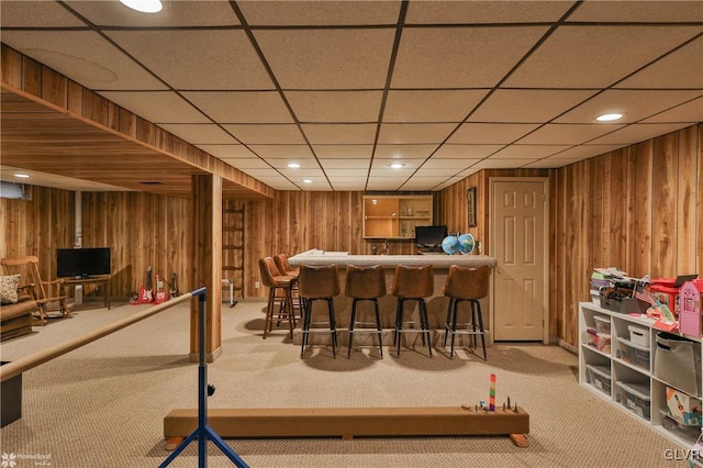 bar with carpet floors, recessed lighting, bar, and wooden walls